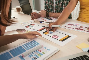 Close-up image of business team choosing icons for new mobile applications